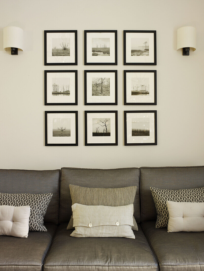 Gerahmte Fotodrucke über dem Sofa in einem Londoner Haus, England, UK