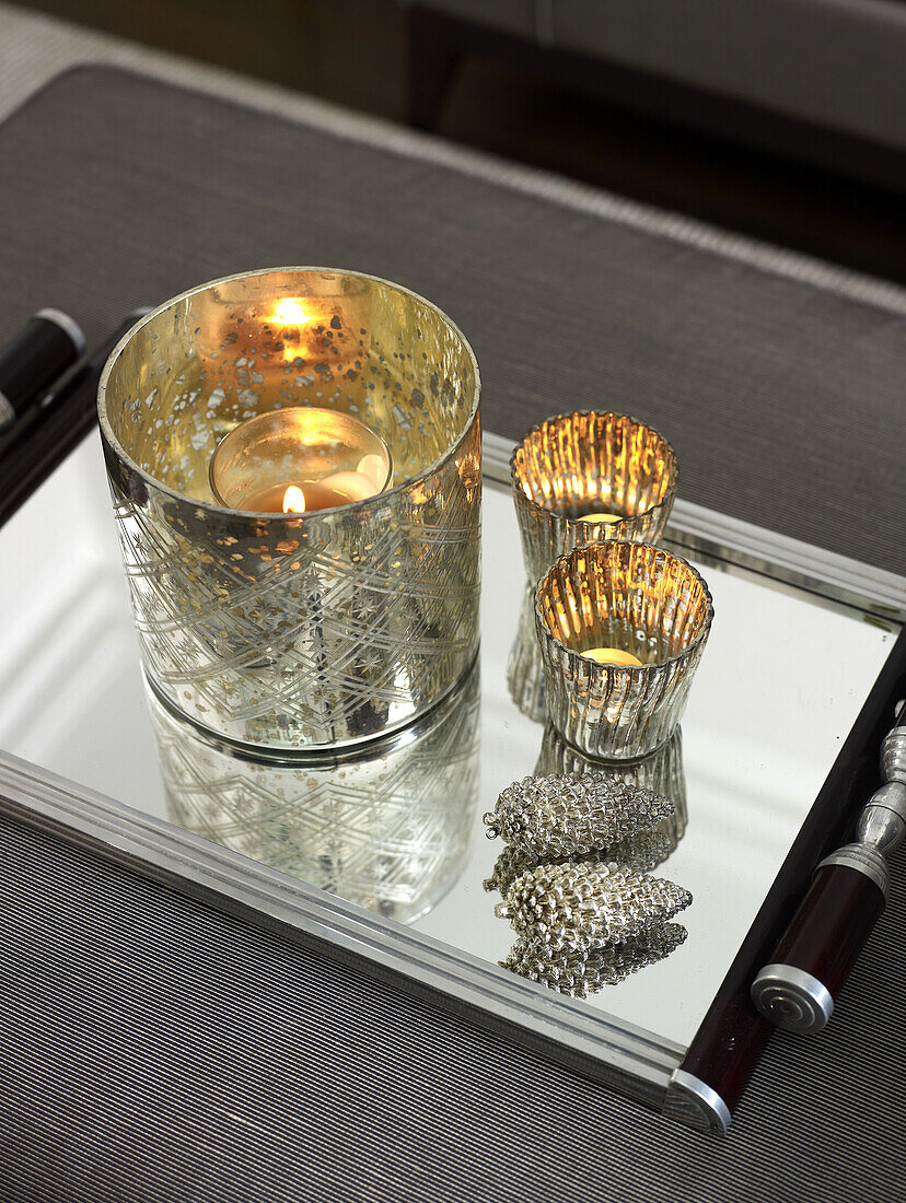 Lit tealights in silver candle holders with tray in London home England UK