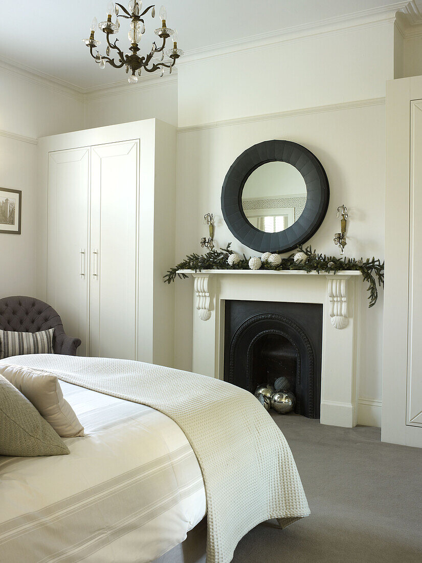 Schwarzer Spiegel über dem Kamin im Schlafzimmer eines klassischen Londoner Hauses England UK