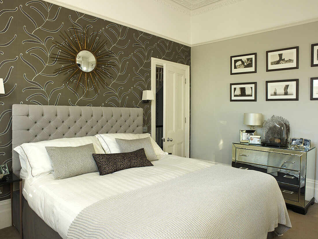 Fotodrucke mit Spiegeltruhe und gemusterter Tapete in einem klassischen Londoner Schlafzimmer, England, UK