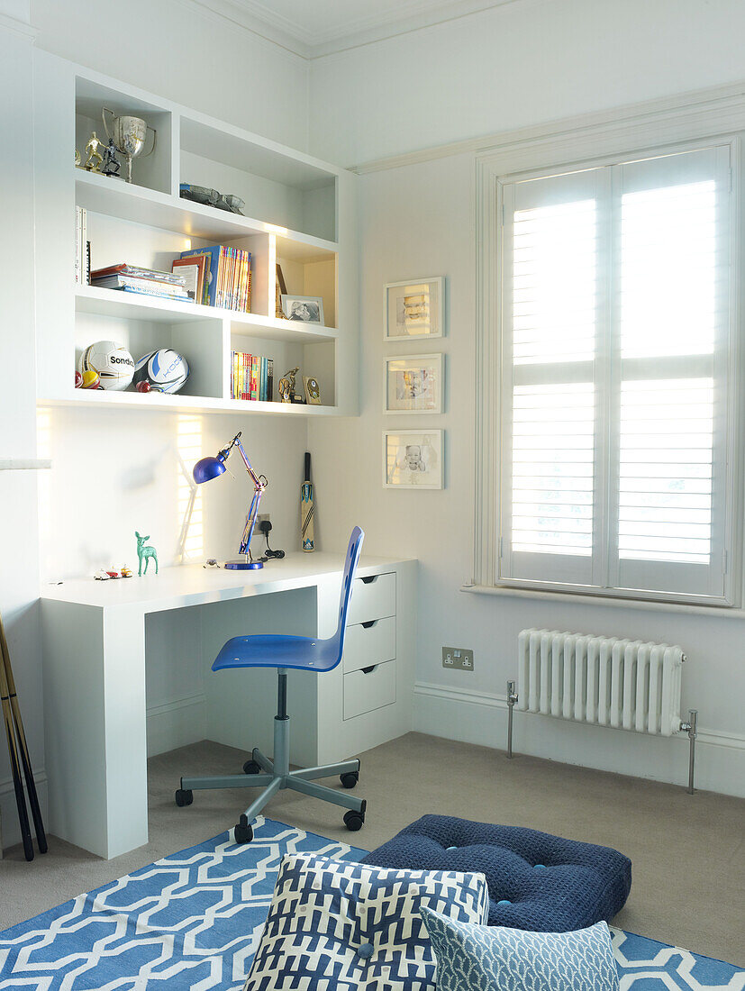 Blauer Stuhl am Schreibtisch im Jungenzimmer eines Hauses in London England UK