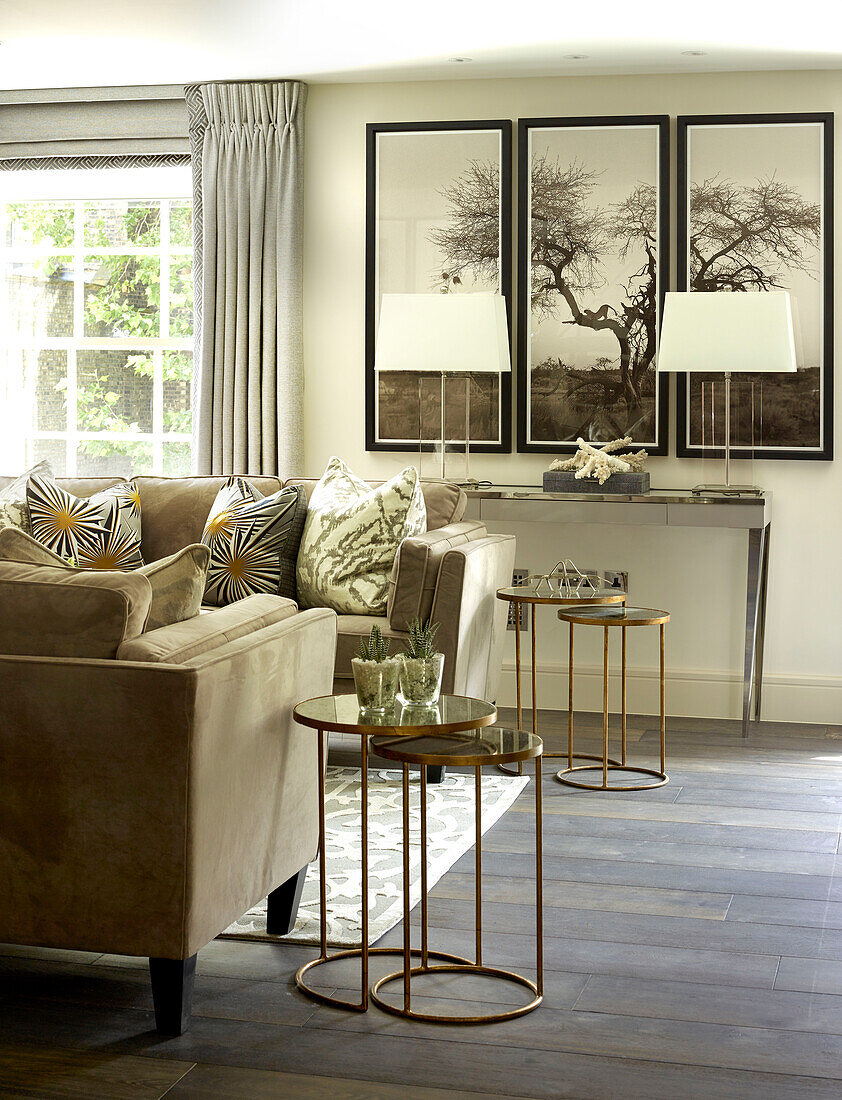 Triptych with bronze nested side tables in living room of London townhouse, UK