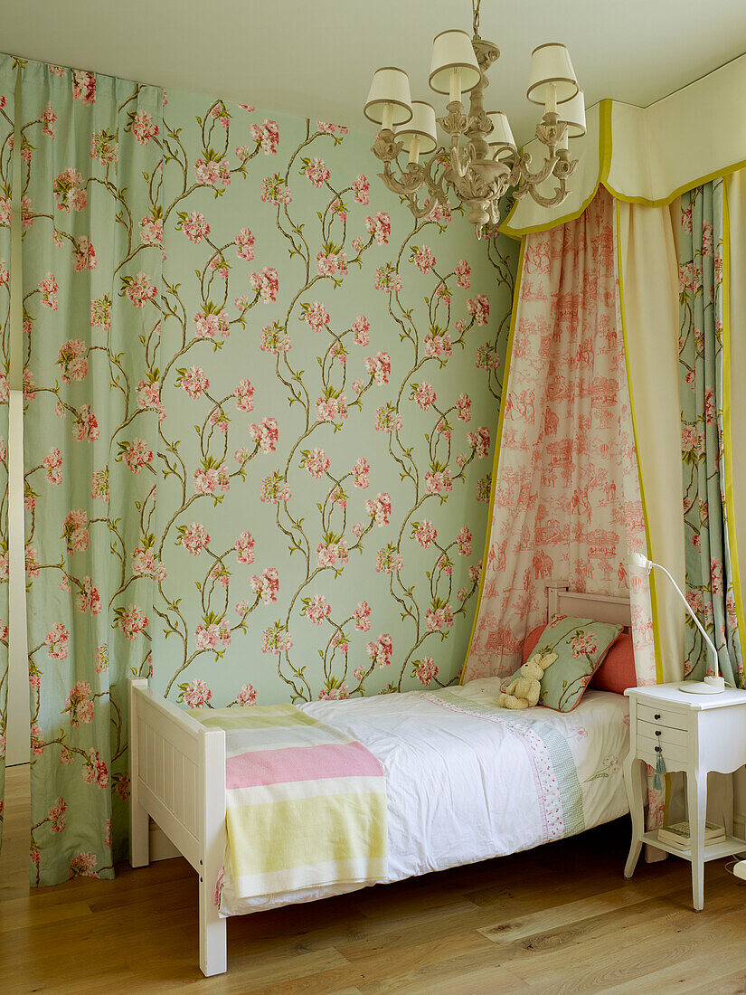 Floral fabric partition and single bed in girl's room of London townhouse, UK