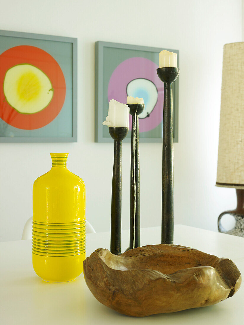 Yellow vase with black candle holders and driftwood bow in London dining room, UK