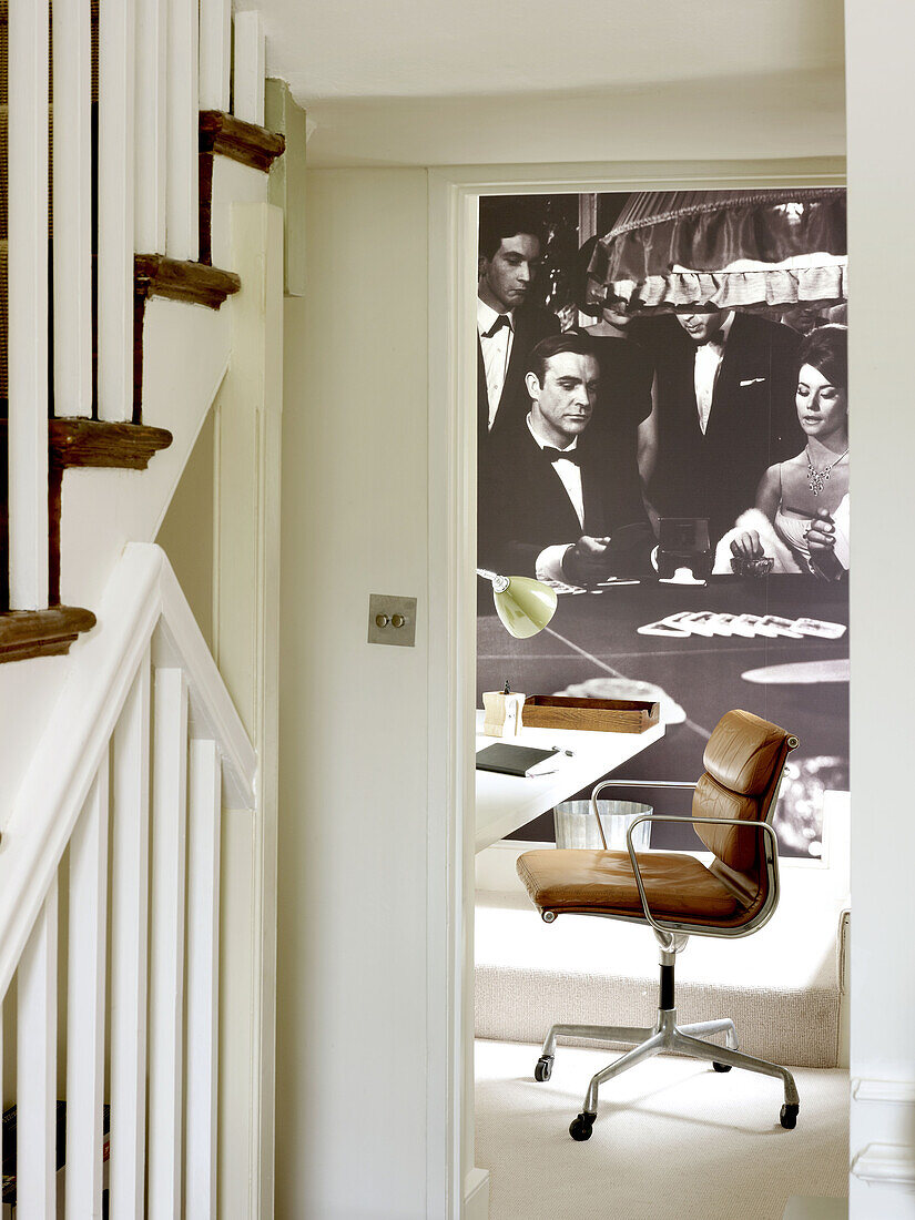 Brown leather armchair with black and white artwork in home office detail of North London townhouse England UK