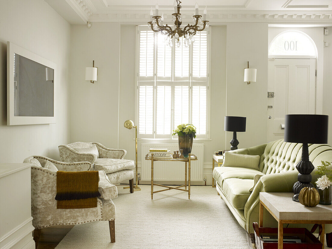 An der Wand montierter Fernseher und Sofa mit passenden Sesseln im Wohnzimmer eines Stadthauses im Norden Londons England UK