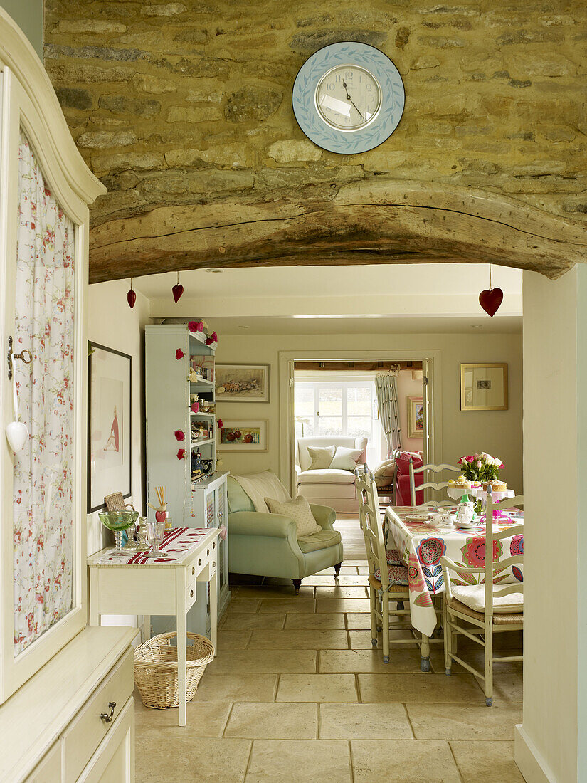 Wanduhr an einer Steinwand mit Blick auf das Esszimmer in einem Haus in Nottinghamshire, England, UK