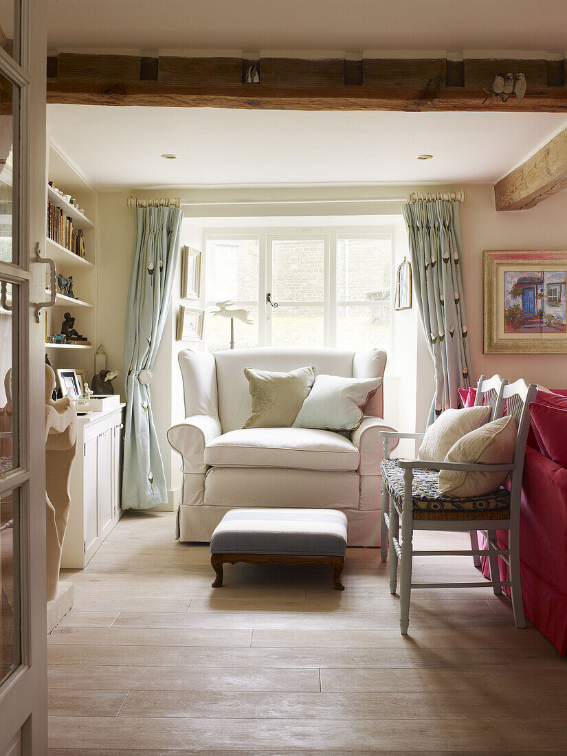 Armchair and footstool at window of Nottinghamshire living room England UK