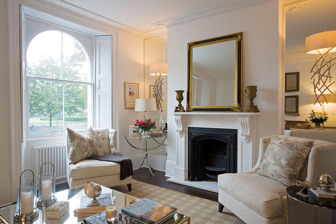 Gilt mirror on fireplace of cream living room in London home UK