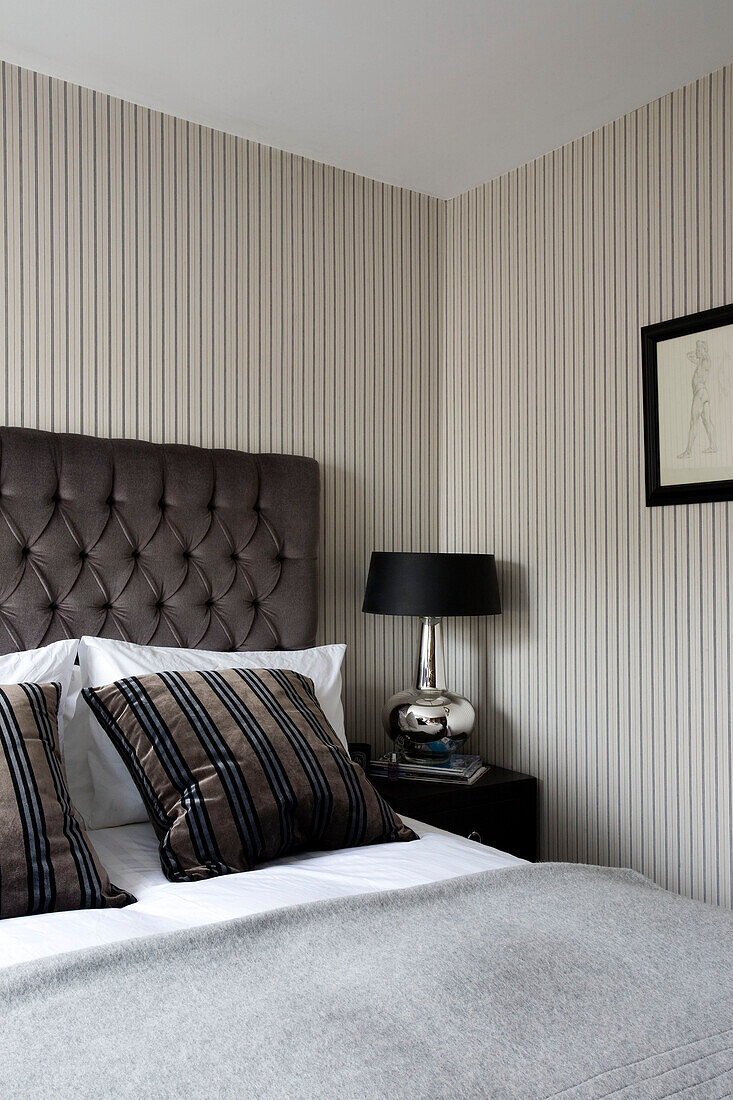 Striped cushions and metal lamp in London bedroom UK