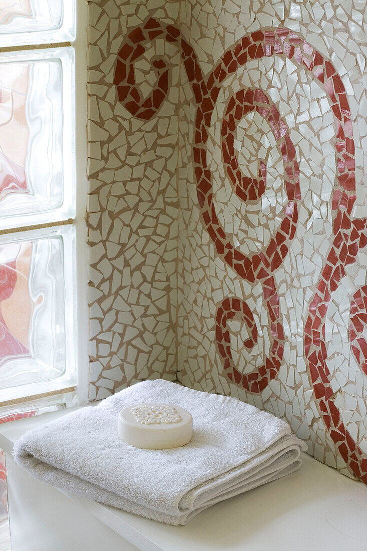 Seife auf gefaltetem Handtuch mit Mosaikfliesen und Glasbausteinen in einem Haus in Cambridgeshire UK