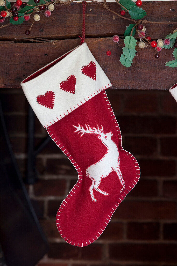 Christmas stocking hangs above fireplace in Kent home, England, UK