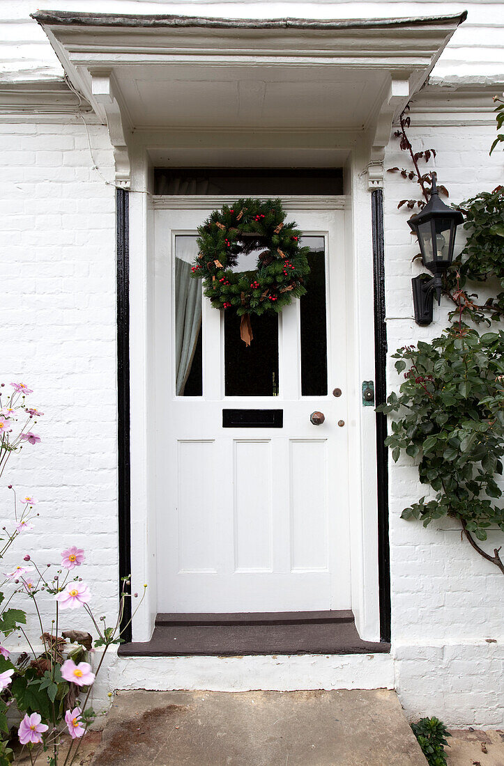 Weihnachtskranz an der weißen Eingangstür eines Hauses in Kent, England, Vereinigtes Königreich
