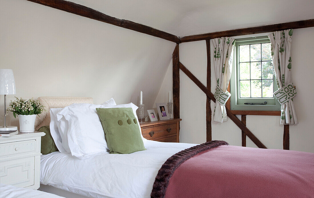 Schlafzimmer im Dachgeschoss mit Sichtholz und Vorhängen in einem Haus in Kent, England, UK