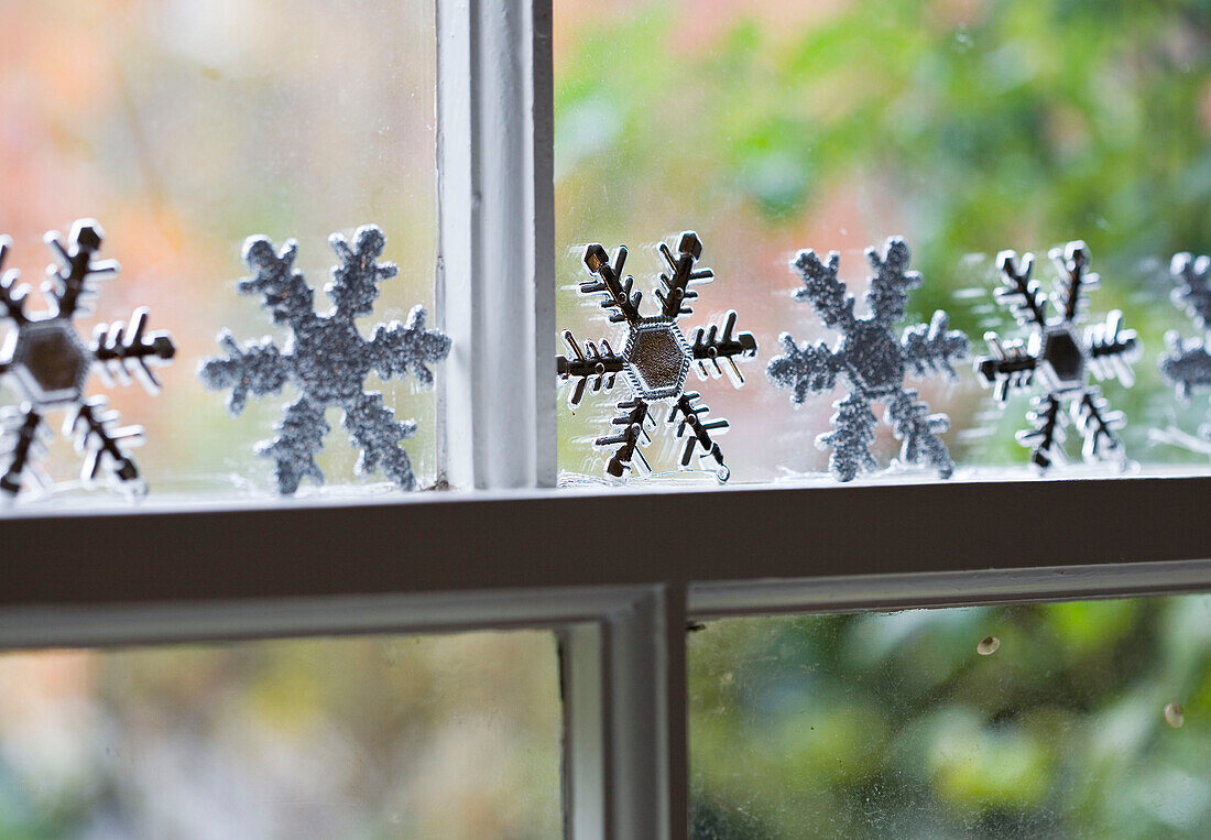 Festive snowflakes on window in living room of London home UK