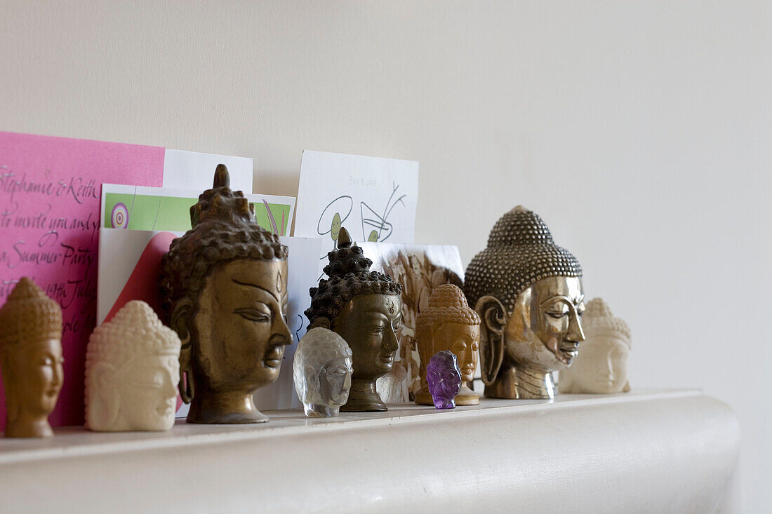 Buddhaköpfe und Schreibpapier auf einem Regal in einem Londoner Haus, UK