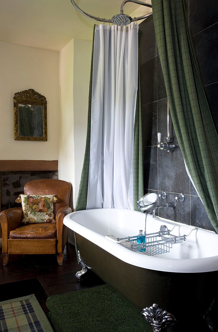 Freistehende Badewanne mit grünem Duschvorhang in einem Haus in Schottland (UK)