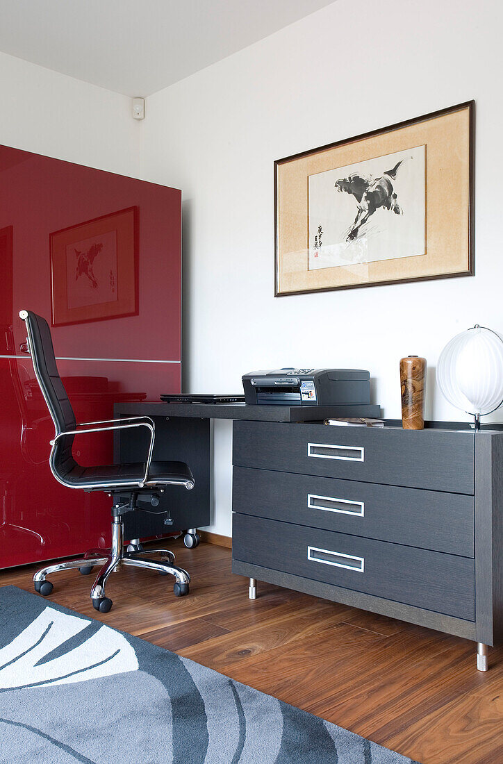 Schreibtisch und Stuhl im Heimbüro mit rotem Schrank in Newmarket, Suffolk UK