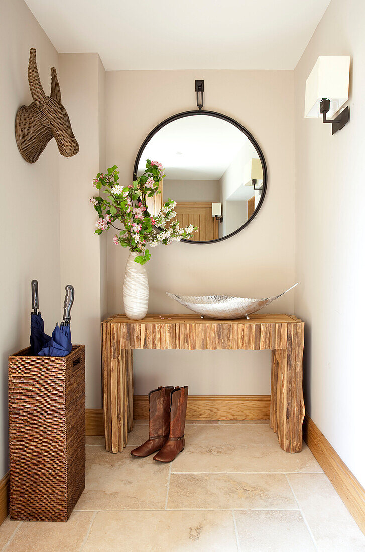 Circular mirror and umbrella stand in Cotswolds entrance hallway UK
