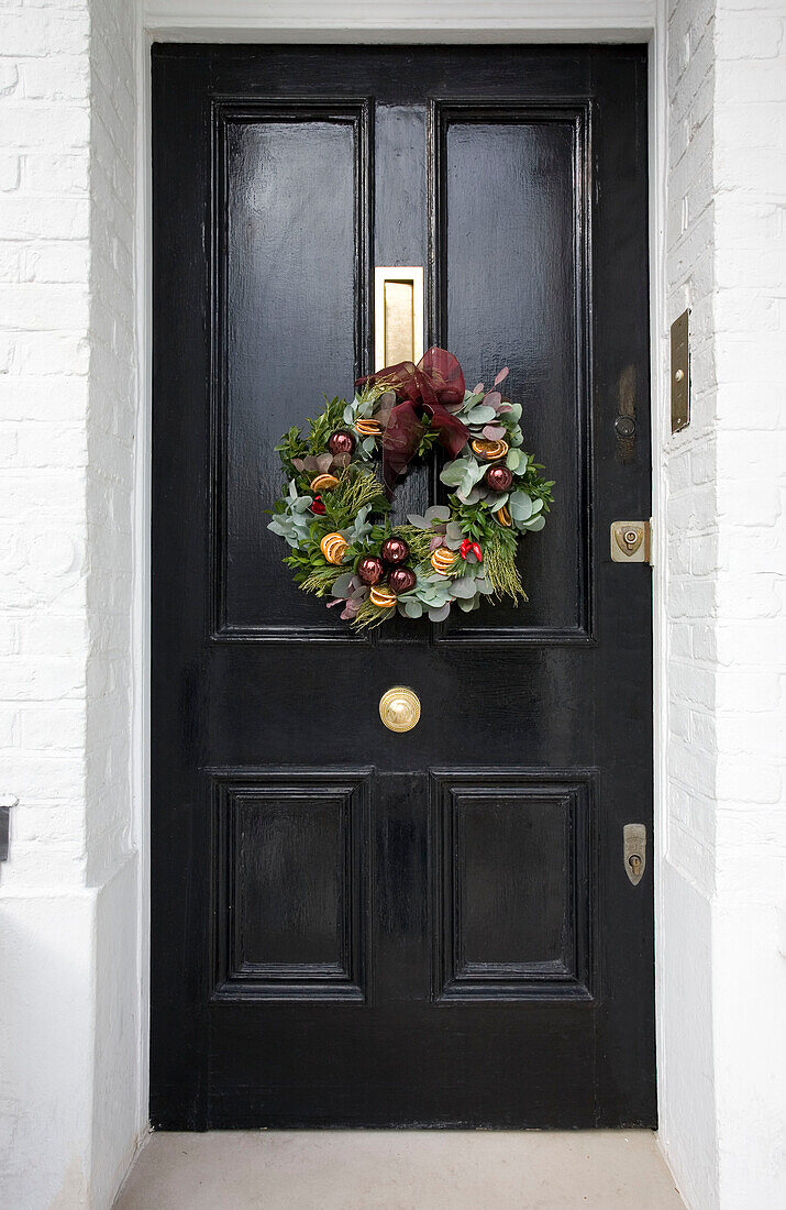 Schwarze Haustür mit Weihnachtsgirlande London UK