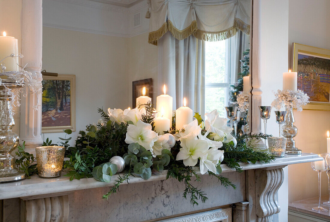 Weiße Lilien und brennende Kerzen, Weihnachtsdekoration in einem Londoner Haus, UK