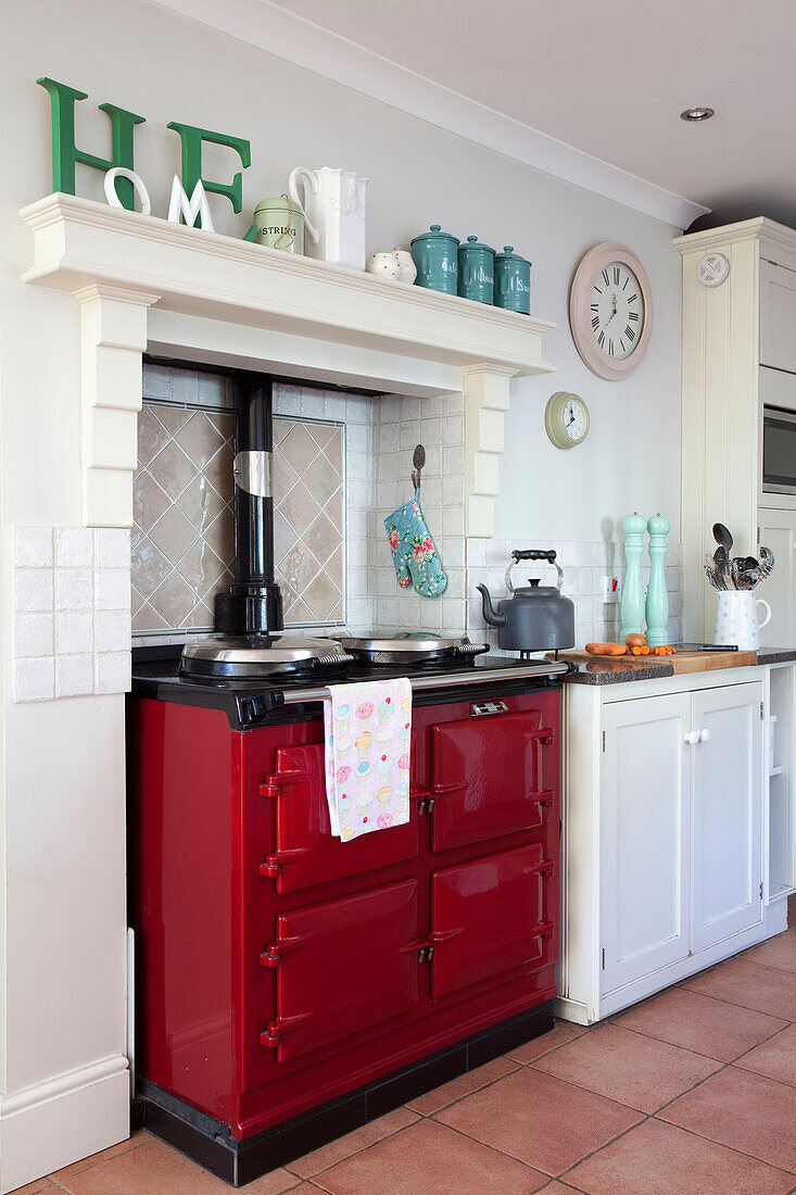 leuchtend roter Herd mit dem Schriftzug 'home' in der weißen Küche eines Hauses in Berkshire, England, UK