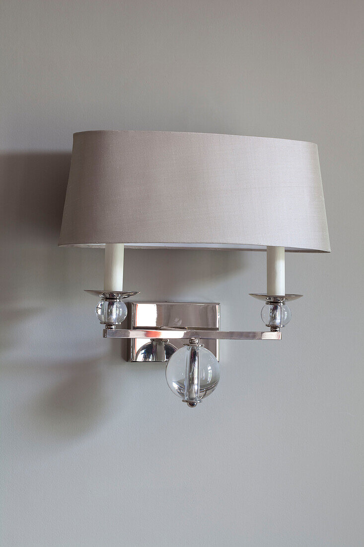Muted metallic lampshade on silver wall scone in contemporary London home, UK
