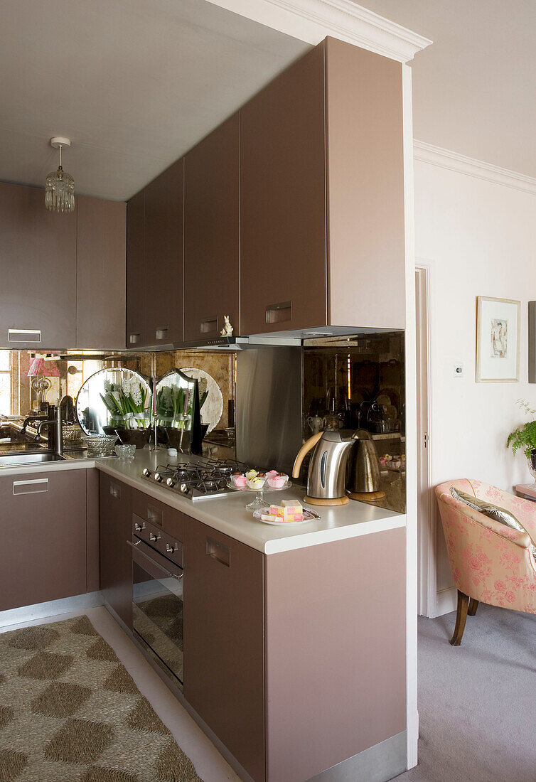 Offene Küche mit braunen Einbauschränken in einem Haus in London, UK