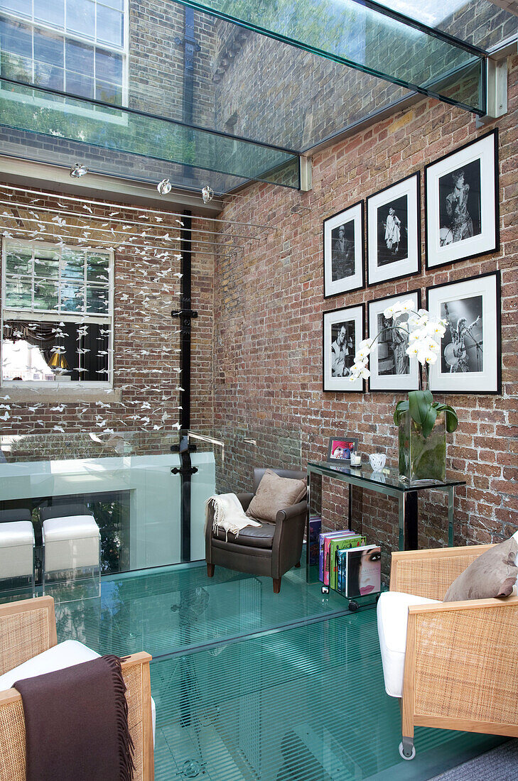 Hauserweiterung mit Ziegelwand und Glasdecke und -böden in einem modernen Londoner Stadthaus, UK