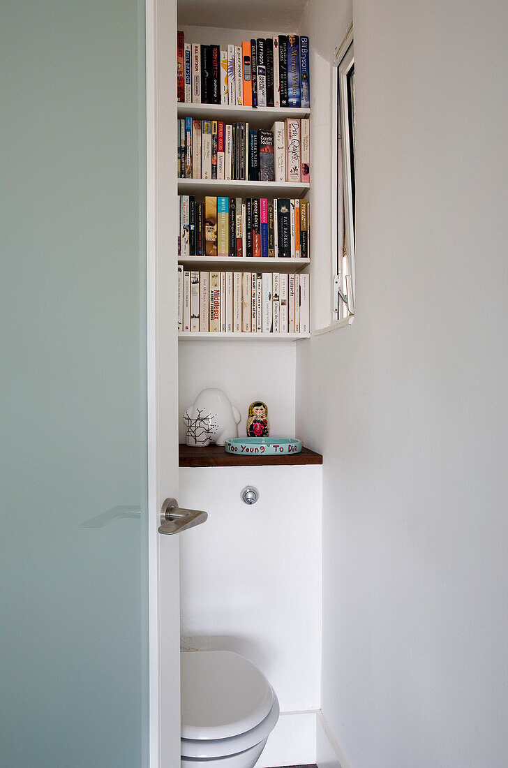 Bücherregal über der Toilette in einem Londoner Haus, UK