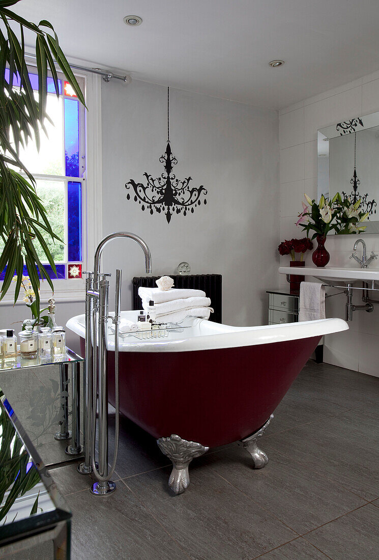 Red slipper bath in spacious contemporary bathroom of London home, UK
