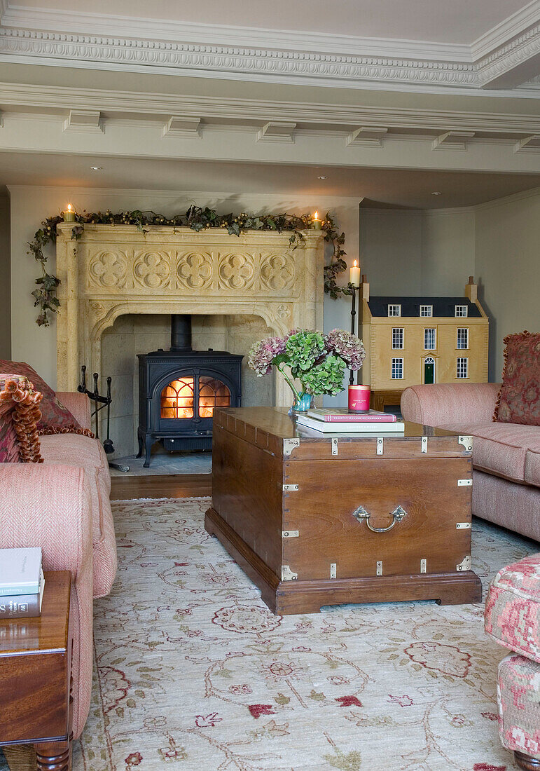 Wooden travelling chest in Surrey home with lit wood burning stove