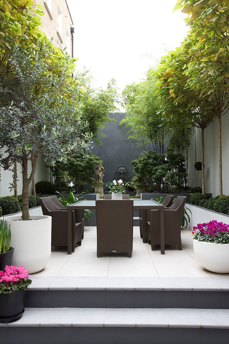 Table for six on terrace in courtyard garden of in contemporary London townhouse, England, UK