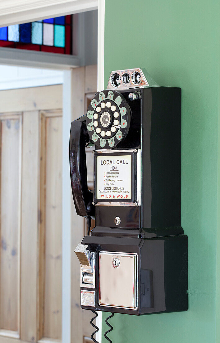 An der Wand montiertes altes Wählscheibentelefon in einem Londoner Stadthaus, England, UK