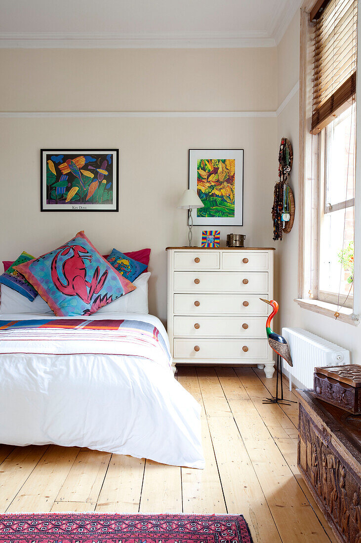 Modernes Kunstwerk über dem Bett in einem Schlafzimmer mit Holzdielenboden in einem Stadthaus in London, England, Vereinigtes Königreich