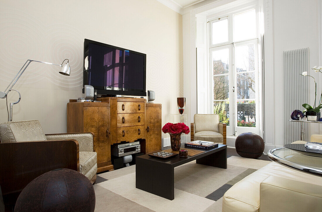 plasma screen on antique side unit in living room of London townhouse