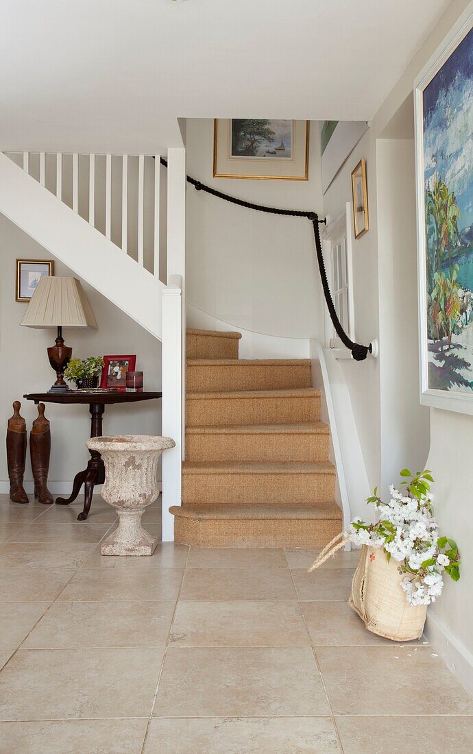 Cut flowers in bag and staircase with coir matting in Kent home, England, UK