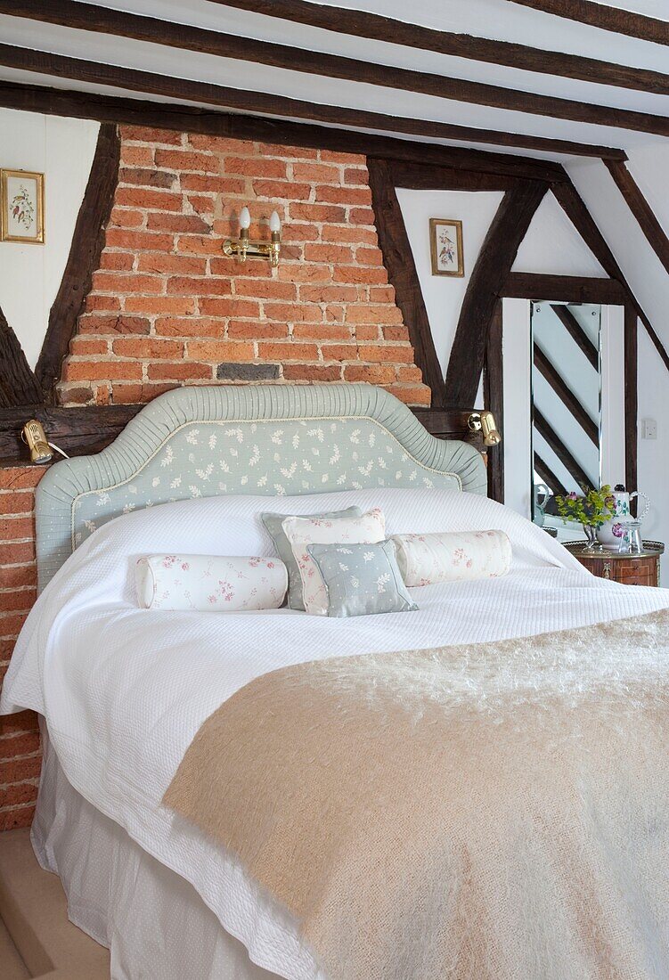 Cream blanket on bed in timber framed cottage, Kent, England, UK
