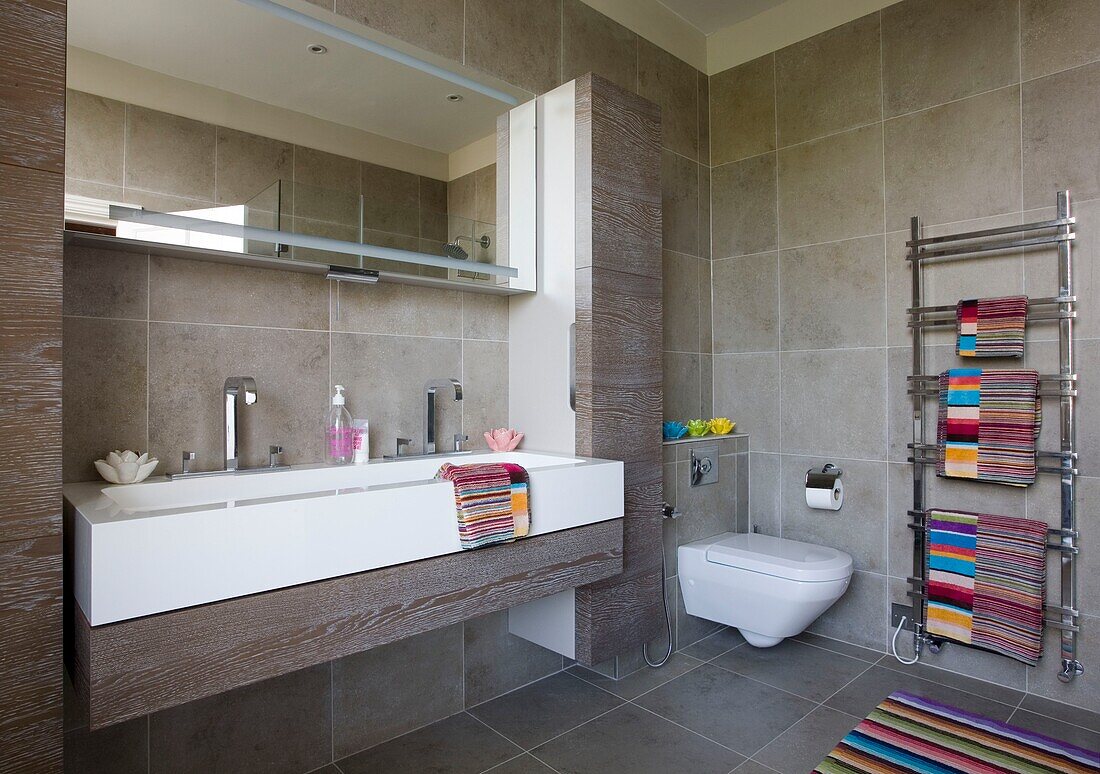 Multicoloured towels in bathroom with double basin London UK