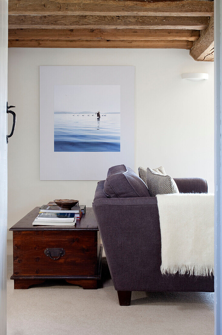 Decke auf Sofa mit Reisetruhe und Kunstwerken in einem Holzhaus in Kent UK