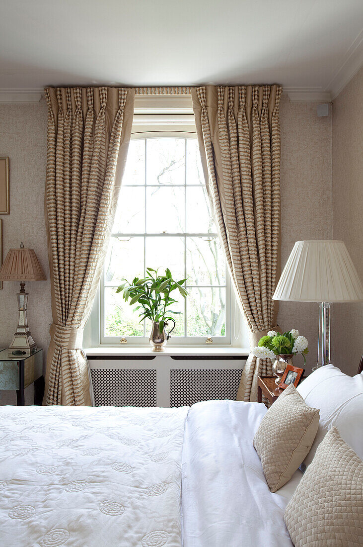 Geschnittene Lilien auf der Fensterbank im Schlafzimmer eines modernen Londoner Stadthauses, England, Vereinigtes Königreich