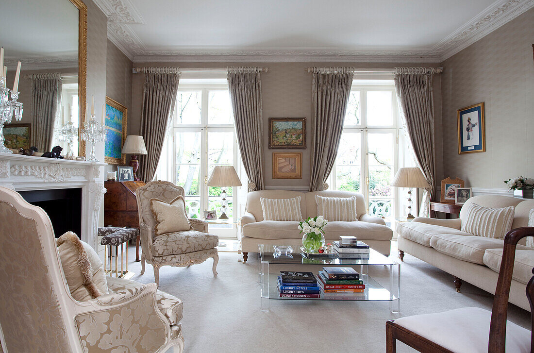 Neutral drawing room with glass coffee table in contemporary London townhouse, England, UK