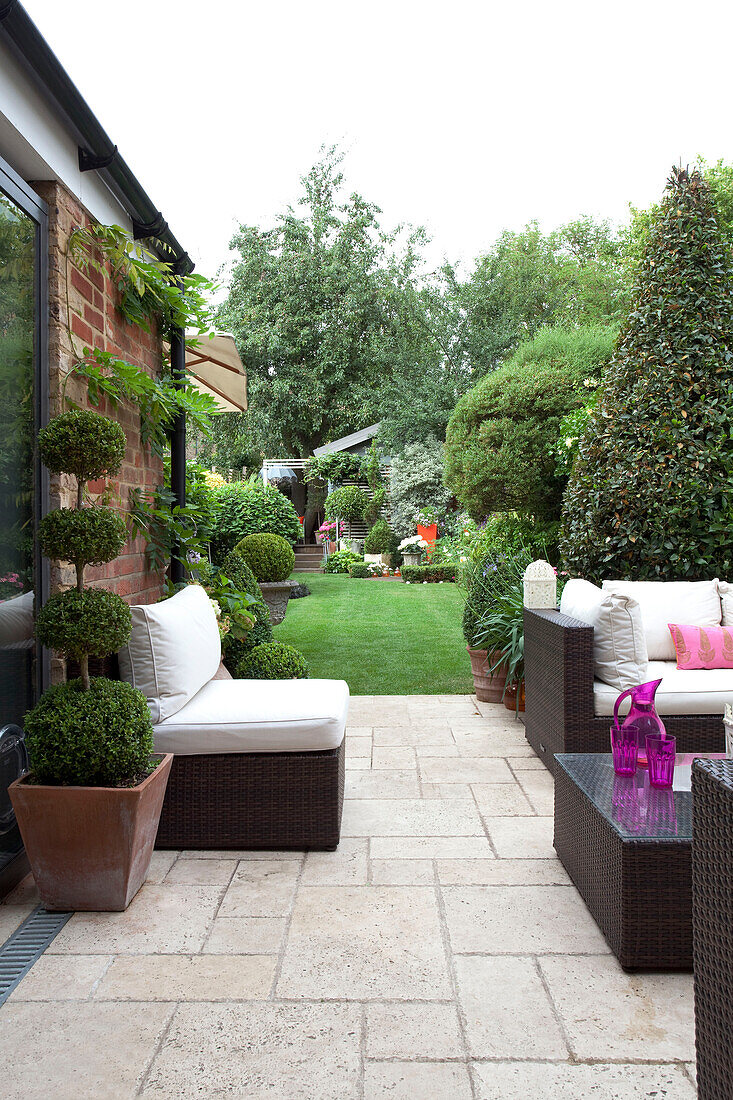 Outdoor seating on paved terrace, exterior of London home, UK