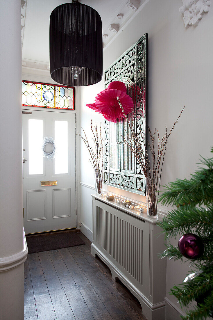 Dekorativer Spiegel über einem Heizkörper in einem modernen Flur eines Hauses in London, UK