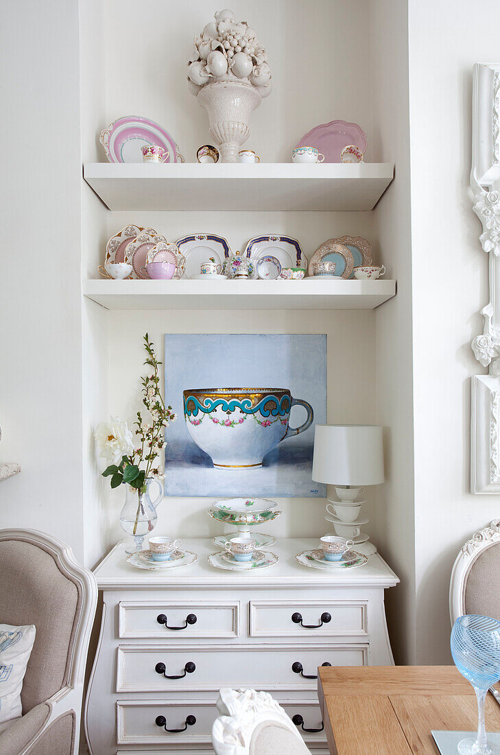extensive collection of chinaware and canvas in living room alcove of London home, UK