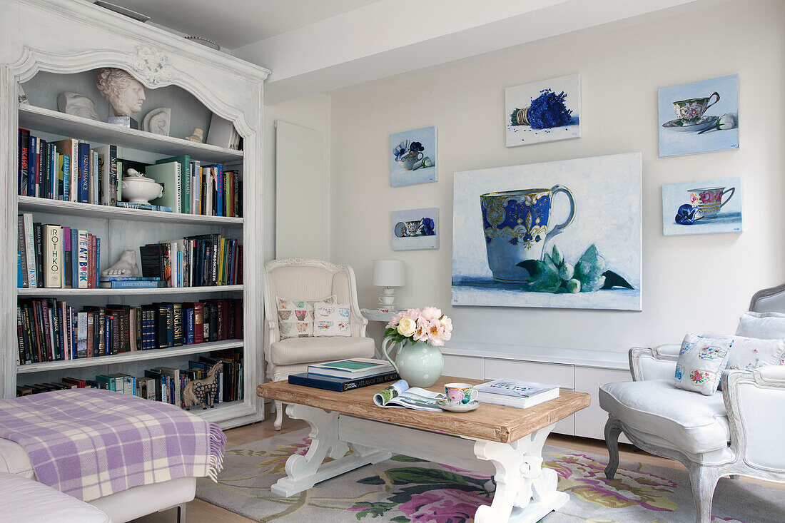 Leinwand aus Porzellan und Bücherregal mit Sesseln und Couchtisch in einem Londoner Haus, UK
