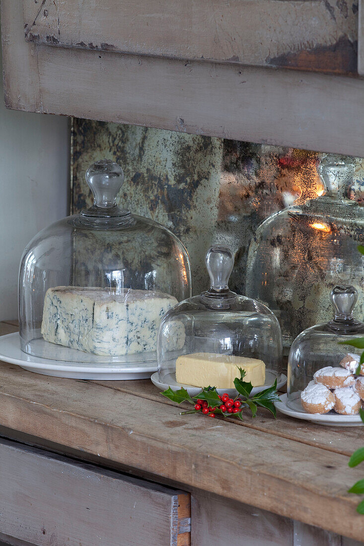 Cheese and butter with iced cakes under glass in London townhouse, England, UK