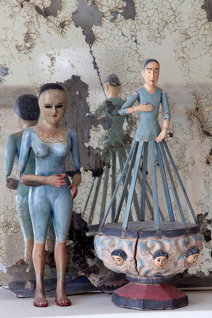 Old figurines and distressed mirror on mantlepiece in London townhouse, England, UK