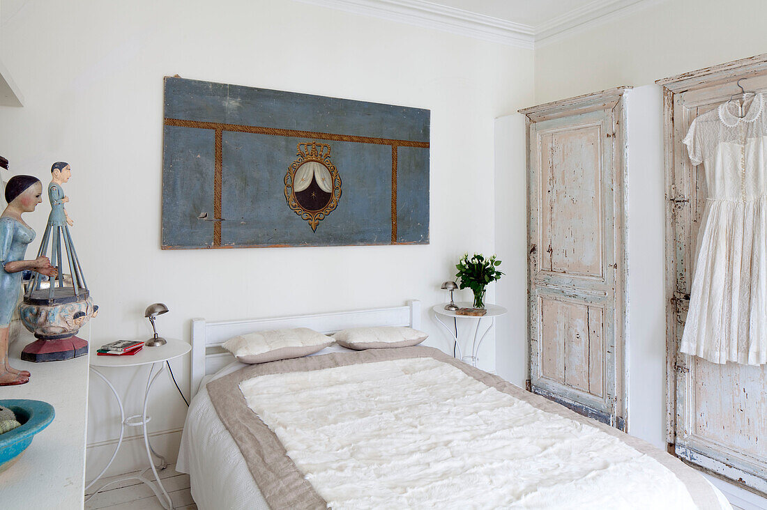 Double bed with architecturally salvaged doors in London townhouse, England, UK