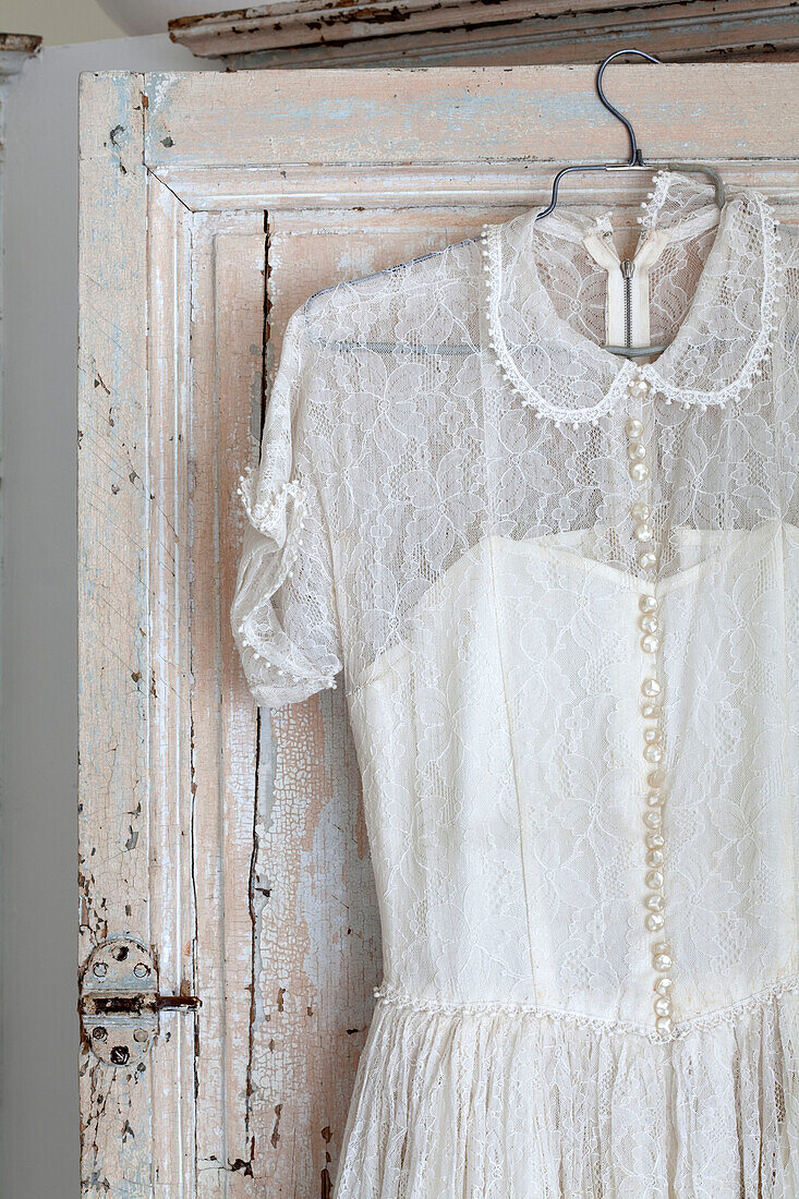 Lace dress hanging on salvaged cupboard in London townhouse, England, UK